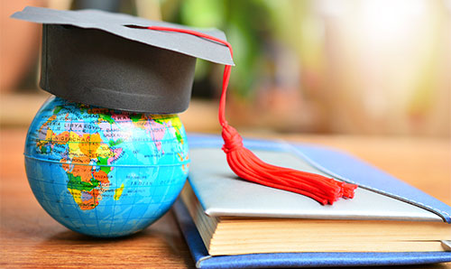 Student cap placed on a small globe